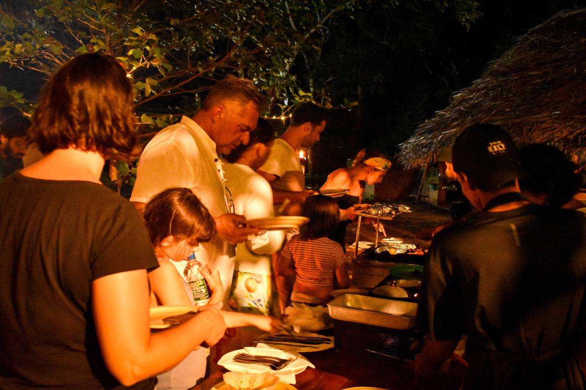 Guests serving themselves at Hambu Café's evening buffet dinner under string lights