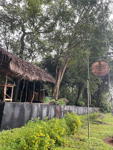 Circular concrete pod structure at Hambu Café framed by green foliage