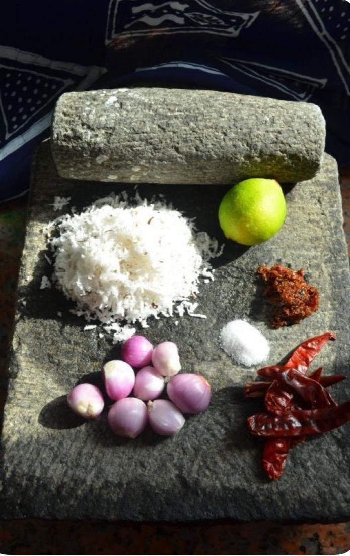 Grinding coconut sambol on a traditional stone at Hambu Café