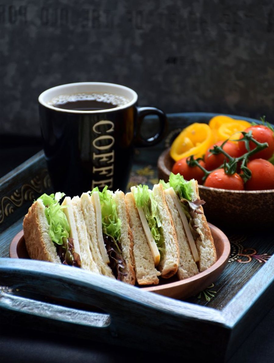 Coffee and a club sandwich on a tray at Hambu Café