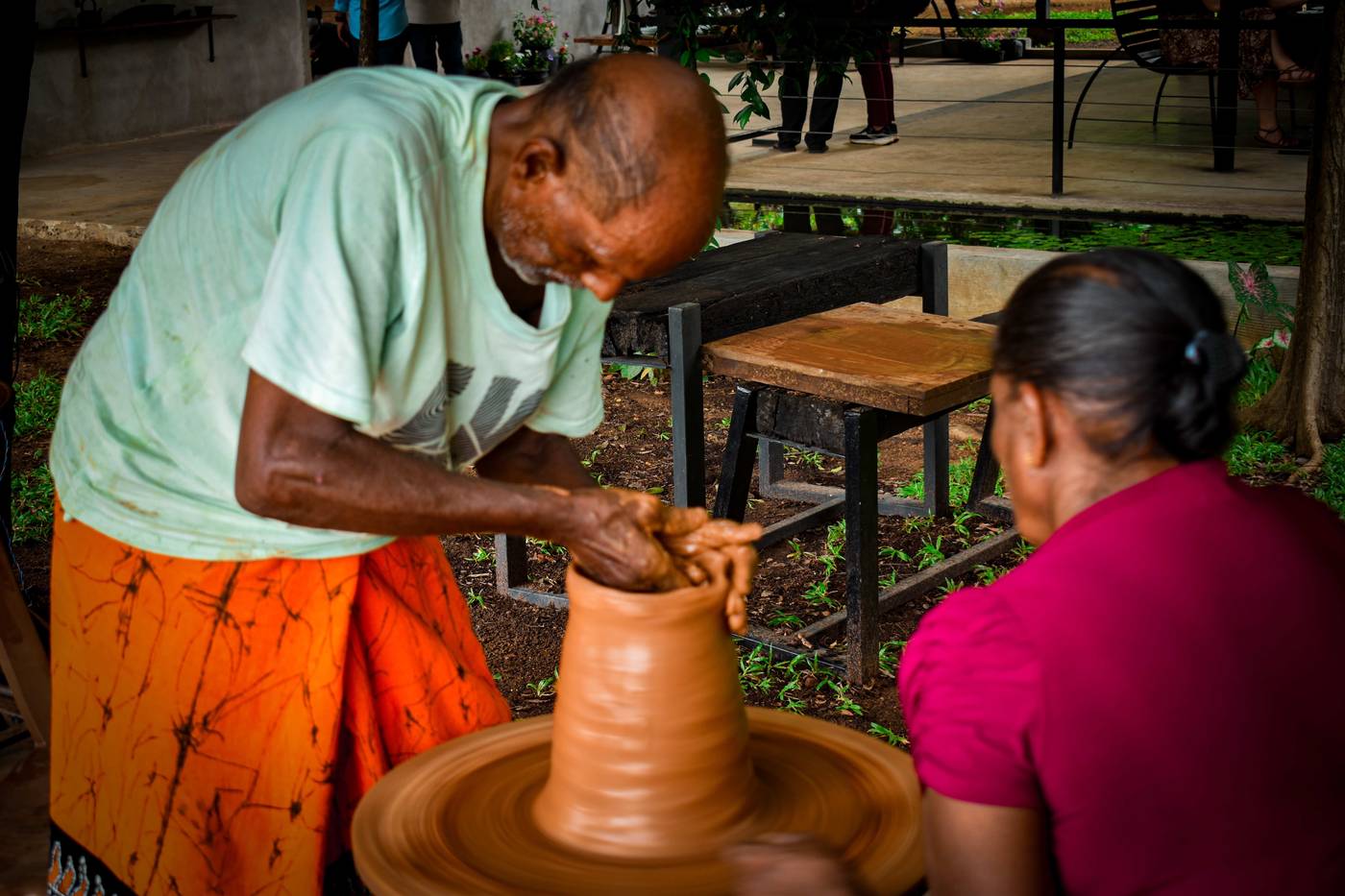 A local potter shaping clay on a pottery wheel during a workshop at Hambu Café
